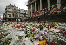 A general view of the tributes left for the victims of the recent bomb attacks in Brussels, following heavy rain in the Place de la Bourse in Brussels, Monday, March, 28, 2016. The Belgian health minister says four of those wounded in the suicide bombings last week have died in the hospital.