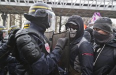 Masked students face-off French police officers during a rally to protest the new labor law in Paris, Thursday, March 31, 2016. Students and workers hold street protests across France while train drivers, teachers and others are on strike to reject a government reform relaxing the 35-hour workweek and other labor rules. AP/Michel Euler
