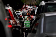 In this Wednesday, Feb. 10, 2016 photo, a Syrian refugee girl begs for money in traffic, in Beirut, Lebanon. A study published last year by the International Labor Organization, UNICEF and the Save the Children charity organization found there are more than 1,500 children living or working on Lebanon's streets, nearly three-quarters of them Syrian and most making a living by begging or roadside vending.