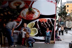 In this Friday, March 25, 2016 photo, a Syrian refugee woman, right, and her children beg for money on a sidewalk, in Beirut, Lebanon. A study published last year by the International Labor Organization, UNICEF and the Save the Children charity organization found there are more than 1,500 children living or working on Lebanon's streets, nearly three-quarters of them Syrian and most making a living by begging or roadside vending. 