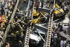 A damaged three-wheeled vehicle is taken out from the rubble of a collapsed overpass in Kolkata, India, Friday, April 1, 2016. The overpass spanned nearly the width of the street and was designed to ease traffic through the densely crowded Bara Bazaar neighborhood in the capital of the east Indian state of West Bengal. About 100 meters (300 feet) of the overpass fell, while other sections remained standing. 