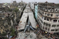 General view shows a partially collapsed overpass in Kolkata, India, Friday, April 1, 2016. The overpass spanned nearly the width of the street and was designed to ease traffic through the densely crowded Bara Bazaar neighborhood in the capital of the east Indian state of West Bengal. About 100 meters (300 feet) of the overpass fell, while other sections remained standing. 
