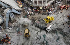 Excavator machines remove debris of a partially collapsed overpass in Kolkata, India, Friday, April 1, 2016. The overpass spanned nearly the width of the street and was designed to ease traffic through the densely crowded Bara Bazaar neighborhood in the capital of the east Indian state of West Bengal. About 100 meters (300 feet) of the overpass fell, while other sections remained standing.