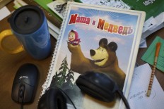 In this Wednesday, March 2, 2016 photo, a notebook with the characters of cartoon TV series 'Masha and the Bear' lays on the desk at the company's office in Moscow, Russia. Masha and the Bear, a Russian animated television series launched in 2009, now broadcasts in more than 120 countries including the United States. Its YouTube channel is in the top 10 most-viewed worldwide.