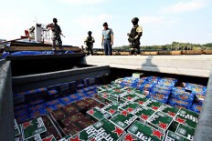 Prohibited -- Members of the Navy's elite frogmen command (Kopaska) and Sea Security Force from Western Fleet Quick Response IV check the cargo of KM Kawal Bahari 1 and KM Kharisma Indah at the Lantamal IV Port at Tanjung Pinang, Riau Islands on March 20. The two boats were arrested when sailing from Singapore and hiding 500 sacks of sugar, 1,000 sacks of rice, 50 boxes of cigarettes, 4,000 cases of alcohol and several other types of goods.
