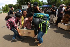 A female farmer from Mount Kendeng in Rembang regency, Central Java, is carried by several supporters during a protest in which she and eight other women placed their feet in cement in front of the State Palace in Jakarta. The Jakarta Post/Wienda Parwitasari