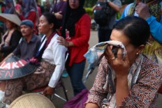 A woman wipes her eyes while taking part in the protest of a planned cement plant in Rembang. The nine protestors demanded a meeting with the President to voice their concerns over the cement plant construction, saying it would harm the environment and threaten their livelihoods as farmers. The Jakarta Post/Wienda Parwitasari