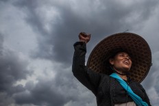 One of the women shouts during the protest as the sky darkens behind her. The Jakarta Post/Seto Wardhana