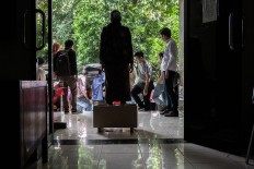 A protestor waits for assistance from supporters while her feet remain in cement. The Jakarta Post/Seto Wardhana