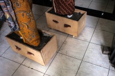 The cemented feet of two of the female farmers are seen as they wait indoors. The Jakarta Post/Seto Wardhana