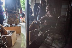 One of the protestors rests in a wheelchair as the group prepares to leave the Jakarta LBH office to continue their rally outside the State Palace. The Jakarta Post/Seto Wardhana