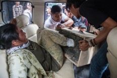 One of the women is helped into a car by volunteers from the Jakarta Legal Aid Institute (LBH Jakarta). The Jakarta Post/Seto Wardhana