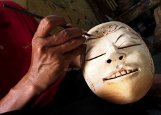 Carving a mask from a piece of wood is part of the process of mask making . JP/ Ganug Nugroho Adi