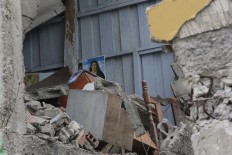 A police officer stands on debris, next to buildings destroyed by an earthquake in Pedernales, Ecuador, Sunday, April 17, 2016. The strongest earthquake to hit Ecuador in decades flattened buildings and buckled highways along its Pacific coast, sending the Andean nation into a state of emergency. AP Photo/Dolores Ochoa