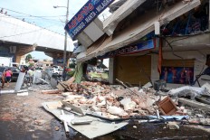 An advertisement for nutritional supplements stands amid the debris left behind by an earthquake in Pedernales, Ecuador, Sunday, April 17, 2016. Rescuers pulled survivors from the rubble Sunday after the strongest earthquake to hit Ecuador in decades flattened buildings and buckled highways along its Pacific coast on Saturday. The magnitude-7.8 quake killed hundreds of people. AP Photo/Patricio Ramos