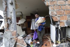 A man searches for his belongings in his earthquake damaged house in Pedernales, Ecuador, Sunday, April 17, 2016. The strongest earthquake to hit Ecuador in decades flattened buildings and buckled highways along its Pacific coast, sending the Andean nation into a state of emergency. AP Photo/Dolores Ochoa