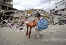 A woman carries a table through the street after an earthquake in Pedernales, Ecuador, Sunday, April 17, 2016. Rescuers pulled survivors from the rubble Sunday after the strongest earthquake to hit Ecuador in decades flattened buildings and buckled highways along its Pacific coast on Saturday. The magnitude-7.8 quake killed hundreds of people. AP Photo/Dolores Ochoa