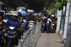 Alfini asks a group of motorcycles attempting to avoid traffic by trespassing on a sidewalk to turn back at Jalan Sudirman Jakarta on Monday. She took action to protest unruly bikers. The Jakarta Post/ Dhoni Setiawan