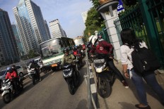 Alfini daringly blocks a group of motorcycles attempting to avoid traffic by trespassing on a sidewalk on Jl Sudirman in Jakarta on Monday. She took action to protest unruly bikers. The Jakarta Post/ Dhoni Setiawan
