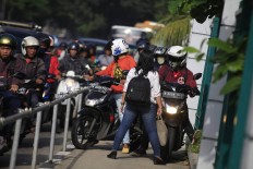 Alfini daringly blocks a group of motorcycles attempting to avoid traffic by trespassing on a sidewalk on Jl Sudirman in Jakarta on Monday. She took action to protest unruly bikers. The Jakarta Post/ Dhoni Setiawan

