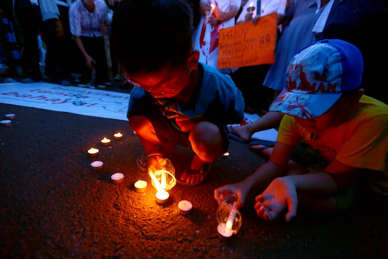 Activists of Komite Aksi Perempuan light candles as a sign their protest during a vigil for teenage girl who was raped and murdered by 14 men in Bengkulu province, Sumatera, in front of the presidential palace, Jakarta on Wednesday 4 May 2016.