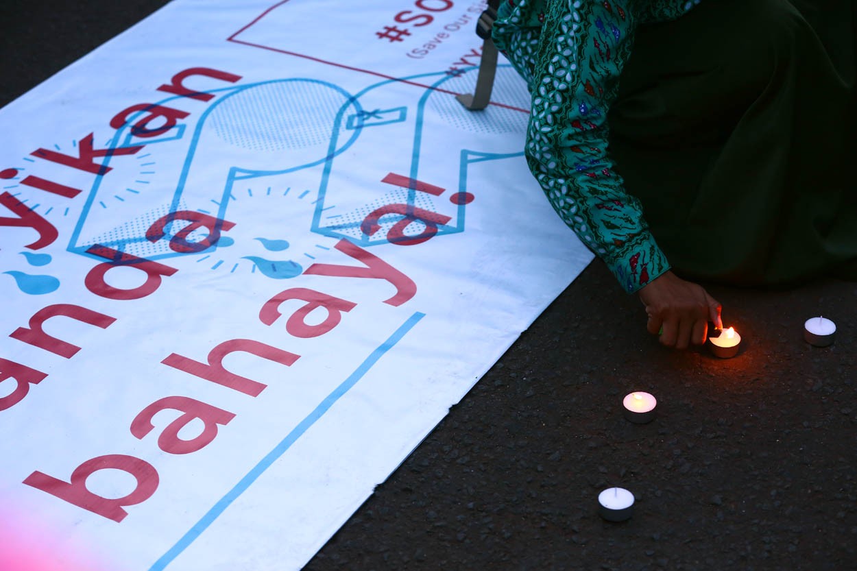 Activists light candles in front of the Presidential Palace in Jakarta on May 4 in solidarity with a 14-year-old girl who was raped and murdered in Bengkulu earlier this year.