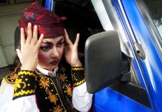 A dancer checks her makeup using a wing mirror before performing in the opening session of the Solo 24 Jam Menari dance festival in the front of the ISI Surakarta campus in Surakarta, Central Java.  JP/ Ganug Nugroho Adi