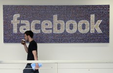 In this March 15, 2013, file photo, a Facebook employee walks past a sign at Facebook headquarters in Menlo Park, Calif. Facebook reports financial results on Wednesday, April 27, 2016. 