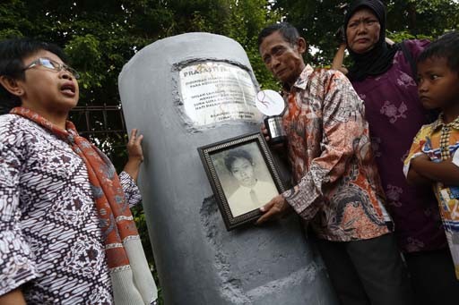 Never forgotten: R. Subiyanto (center), displays a picture of his son, Gunawan, one of over 1,000 victims of the May 1998 riots in Jakarta, with the parents of other victims who mostly perished in a fire that engulfed Yogya mall in Klender, East Jakarta. The picture was taken on May 19, 2013, in front of a memorial for the victims. No one has been held accountable for the riots, which took place in a number of cities. 