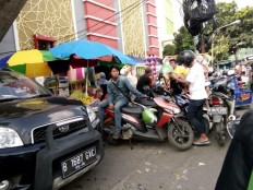 Pedestrians, motorcyclists and vendors do battle over sidewalks