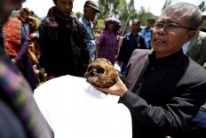 The family members hand over the box of bones to the wife’s family as a sign of respect. JP/ Hotli Simanjuntak