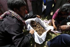 The bones are arranged into a small box after the grave digging is completed. JP/ Hotli Simanjuntak