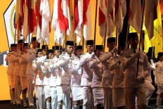 Flag bearers carry red-and-white flags during the opening ceremony of the Golkar extraordinary congress in Bali. JP/Zul Trio Anggono
