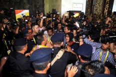 Reporters argue with police after one officer reportedly scolded a female reporter as she was was about to interview a congress participant. JP/Zul Trio Anggono