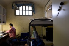 In this Wednesday, April 6, 2016 photo, Afghan refugee Hamed Karmi, 27, plays keyboard next to his wife Farishta Morahami, 25, sitting on a bed inside their room at the former prison of De Koepel in Haarlem, Netherlands. The government has let Belgium and Norway put prisoners in its empty cells and now, amid the huge flow of migrants into Europe, several Dutch prisons have been temporarily pressed into service as asylum seeker centers. AP Photo/Muhammed Muheisen

