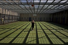 In this Wednesday, April 20, 2016 photo, Mongolian migrant Naaran Baatar, 40, plays basketball at a yard of the former prison of De Koepel in Haarlem, Netherlands.  AP Photo/Muhammed Muheisen
