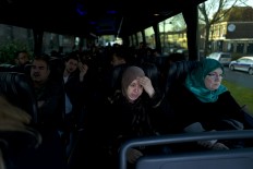 In this Friday, May 6, 2016 photo, Iraqi refugee Fatima Hussein, 65, reacts while she and others wait in a bus heading to have a government interview for their asylum seeking process outside the former prison of De Koepel in Haarlem, Netherlands. With crime declining in the Netherlands, the country is looking at new ways to fill its prisons. The government has let Belgium and Norway put prisoners in its empty cells and now, amid the huge flow of migrants into Europe, several Dutch prisons have been temporarily pressed into service as asylum seeker centers. AP Photo/Muhammed Muheisen