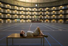 In this Friday, May 6, 2016 photo, Iranian migrant Reda Ehsan, 25, lies on a table at the former prison of De Koepel in Haarlem, Netherlands. With crime declining in the Netherlands, the country is looking at new ways to fill its prisons. The government has let Belgium and Norway put prisoners in its empty cells and now, amid the huge flow of migrants into Europe, several Dutch prisons have been temporarily pressed into service as asylum seeker centers. AP Photo/Muhammed Muheisen