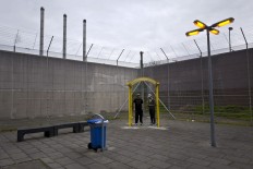 In this Monday, May 2, 2016 photo, Algerian migrant Mohammed Ben Salem, 36, left, and Libyan Amine Oshi, 22, smoke a cigarette at a yard of the former prison of De Koepel in Haarlem, Netherlands. With crime declining in the Netherlands, the country is looking at new ways to fill its prisons. The government has let Belgium and Norway put prisoners in its empty cells and now, amid the huge flow of migrants into Europe, several Dutch prisons have been temporarily pressed into service as asylum seeker centers. AP Photo/Muhammed Muheisen