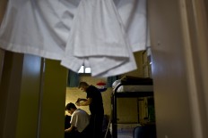In this Thursday, April 21, 2016 photo, Syrian refugee Imad Abdulrahman, 30, gives a haircut to another Syrian refugee in a room at the former prison of De Koepel in Haarlem, Netherlands. AP Photo/Muhammed Muheisen