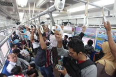 Due to limited seating space, it is not uncommon for passengers to stand, as seen on a train heading to Tanah Abang Station on Sept. 4, 2015. JP/Dhoni Setiawan