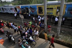 Several officers evacuate a derailed commuter Line train on the Tanah Abang - Parung Panjang route on June 16, 2015. JP/Dhoni Setiawan