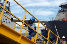 A worker carries a steel pipe for a 10514 PKR frigate in Semarang on April 4. JP/Wahyoe Boediwardhana