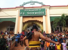 Warok or reog [masked dance] entourage accompanies the procession of the Cembengan offerings to the Tasik Madoe sugar factory. JP/Ganug Nugroho Adi