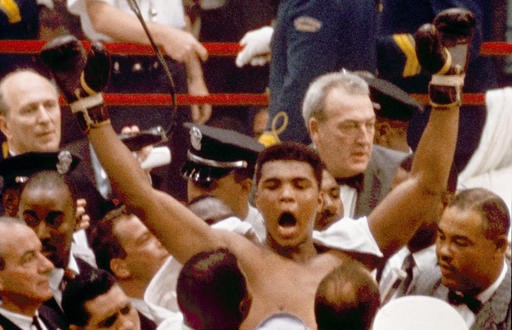 In this Feb. 25, 1964, file photo, Muhammad Ali, or Cassius Clay at the time, strikes a familiar pose as he shouts "I am the greatest," as he leaves the ring, arms raised, following his defeat of former heavyweight boxing champion Sonny Liston, in Miami Beach, Fla. Ali, the magnificent heavyweight champion whose fast fists and irrepressible personality transcended sports and captivated the world, has died according to a statement released by his family Friday, June 3, 2016. He was 74.
