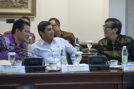 Administrative and Bureaucratic Reform Minister Yuddy Chrisnandi (center) chats with Justice and Human Rights Minister Yasonna Laoly (right)  and chairman of General Election Commission (KPU) Husni Kamil Manik (left) before a limited cabinet meeting at the Presidential Office on May 31. 