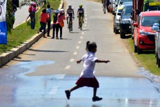A student scurries across the track during the final stage of the Tour de Flores in Labuan Bajo. The Jakarta Post/Markus Makur