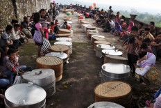 Family members and relatives sit in a circle around containers filled with various cakes and snacks at the Gunung cemetery in Sukabumi, Cepogo, Boyolali in Central Java. The Jakarta Post/ Albertus Magnus Kus Hendratmo