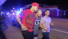 An injured man is escorted out of the Pulse nightclub after a shooting rampage, Sunday morning June 12, 2016, in Orlando, Fla. A gunman wielding an assault-type rifle and a handgun opened fire inside a crowded gay nightclub early Sunday, killing at least 50 people before dying in a gunfight with SWAT officers, police said. It was the deadliest mass shooting in American history. AP Photo/Steven Fernandez