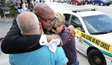 Kelvin Cobaris, a local clergyman, consoles Orlando city commissioner Patty Sheehan, right, and Terry DeCarlo, an Orlando gay-rights advocate, as they arrive on the scene near where a mass shooting occcured in Orlando, Fla., Sunday, June 12, 2016.  Joe Burbank/Orlando Sentinel via AP